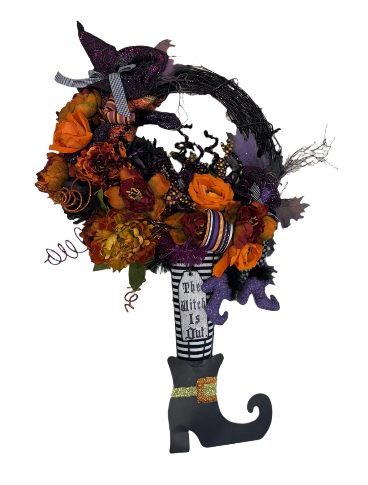 Halloween-themed wreath with flowers, a witch's hat and boot and fauz flowers